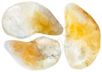 macro shooting of natural mineral stone - three yellow citrine gemstones isolated on white background