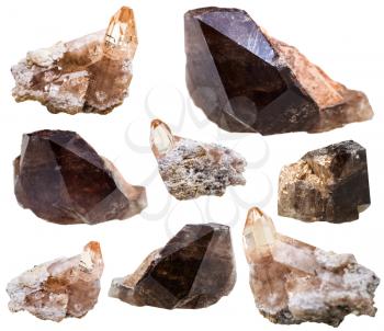 macro shooting of natural mineral stone - set of topaz and Rauchtopaz (morion, smoky quartz) crystals on rocks isolated on white background