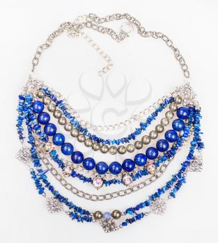 top view of blue necklace from natural gemstones (lapis lazuli - lazurite, pyrite, glass lampwork beads) on white background