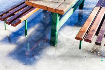 outdoor table and benches frozen in puddle in winter