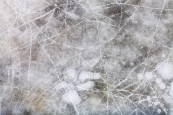 natural background - cracked ice on frozen puddle in cold winter day