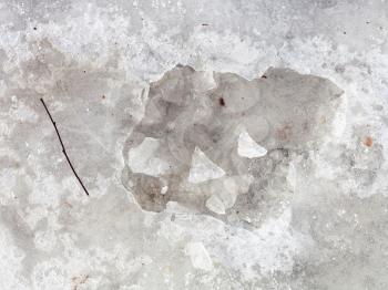 natural background - broken ice crust on frozen puddle in cold winter day
