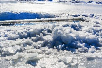 broken ice near hole in frozen lake in winter
