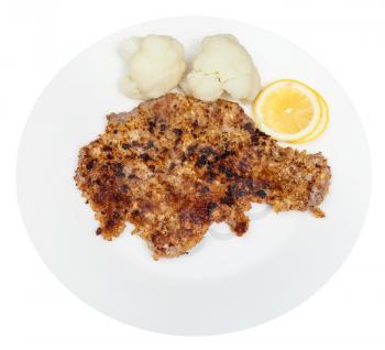top view of fried veal schnitzel, boiled cauliflower, lemon slices on white plate isolated on white background