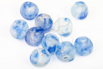 several beads from rough blue painted glass on white background