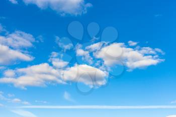 horizontal natural background - blue sky with white clouds and horizontal airplane trail