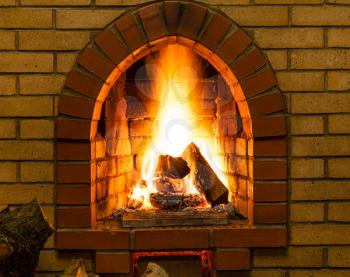 spurts of fire in brick fireplace in country cottage
