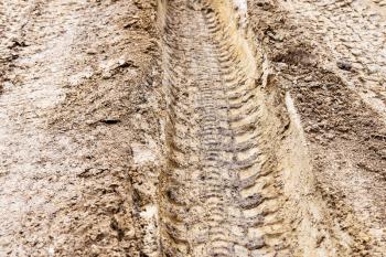 deep ruts of automobile wheels in loamy soil of country road in spring