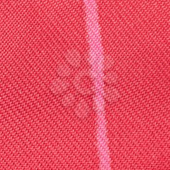 square textile background - red silk fabric with Serge twill weave pattern of threads close up