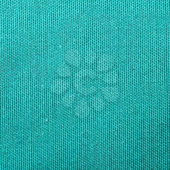 square textile background - silk green Taffeta cloth with plain weave pattern of threads close up