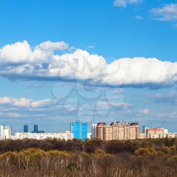 blue sky with white clouds over city and trees in sunny spring day, Moscow, Russia