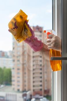 washing home window - cleaner washes window glass with detergent in apartment house