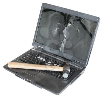 old damaged laptop with hammer on keyboard isolated on white background