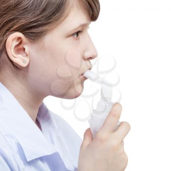 medical inhalation treatment - girl inhales with mouthpiece of modern jet nebulizer isolated on white background