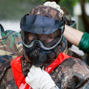 girl in camouflage and protective mask before playing paintball