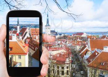 travel concept - tourist photographs Tallinn city cityscape, Estonia on smartphone