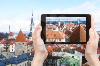 travel concept - tourist photographs Tallinn city skyline, Estonia on tablet pc