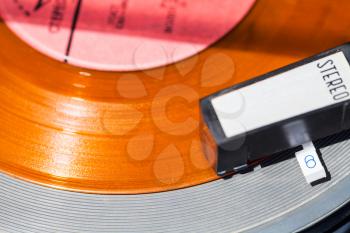 above view of headshell of turntable on orange vinyl record close up