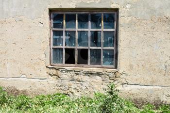window in wall of abandoned building in sunny day