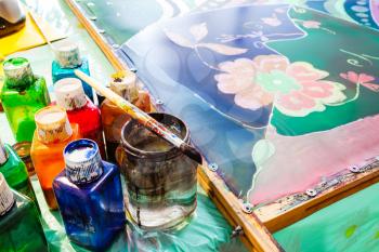 paints, brush and painted silk hot batik in workshop