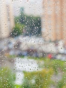 raindrops on window and blurred cityscape on background