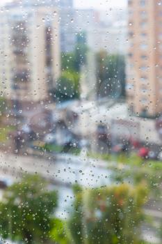 rain drops on window glass and blurred street on background
