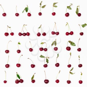 many ripe red cherries arranged on white background