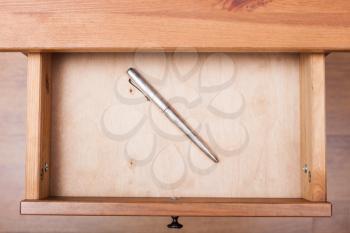 top view of old silver pen in open drawer of nightstand