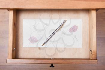 above view of ballpen on vintage envelope in open drawer of nightstand