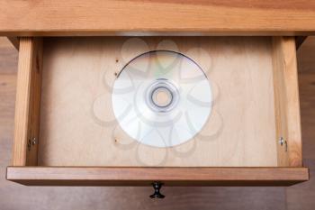 top view of CD disk in open drawer of nightstand