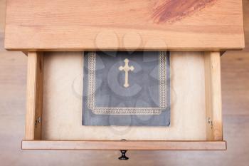 top view of Bible book in open drawer of nightstand