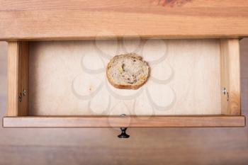 top view of slice of bread in open drawer of nightstand