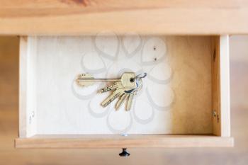 above view of bunch of door keys in open drawer of nightstand