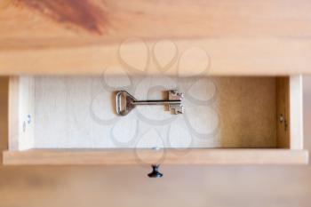 above view of safe key in open drawer of nightstand