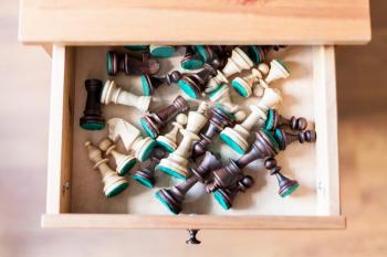 top view of chess figures in open drawer of nightstand