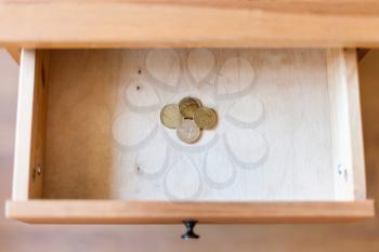 top view of pile of european coins in open drawer of nightstand