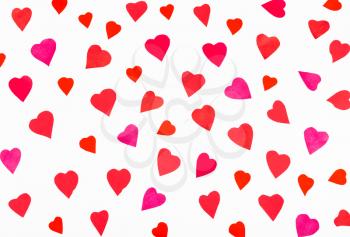 many pink and red hearts carved from paper on white background
