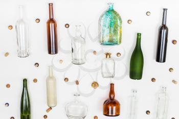 empty glass bottles and corks arranged on white background