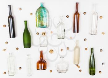 many empty glass bottles and corks on white background