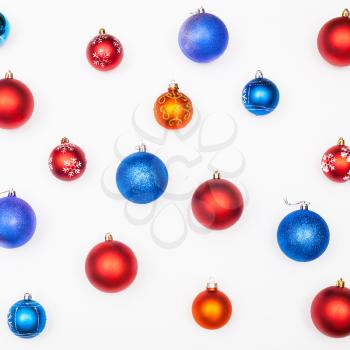 various blue, red, orange christmas balls on white background