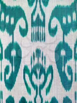 textile background - traditional central asian green decor on silk fabric