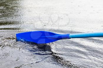 paddle blade in water during boating on the pond in rain