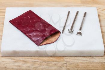 Leathercraft - new handmade leather pouch for glasses and stamping tools on marble plate