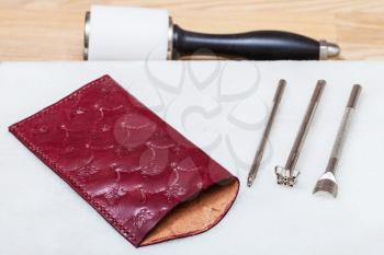 Leathercraft - new handmade leather eyeglass case and stamping tools on marble plate and nylon hammer