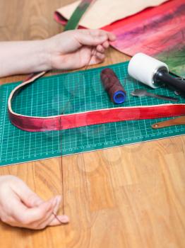 leather-working - craftsman sews new belt for leather bag
