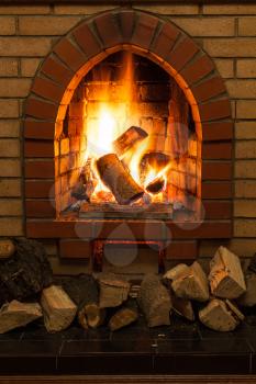 wooden logs and fire in fireplace in country cottage