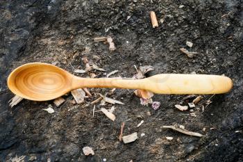 traditional wooden spoon carved from Alder wood lying on ground