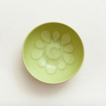 above view of green bowl on white plastering plate