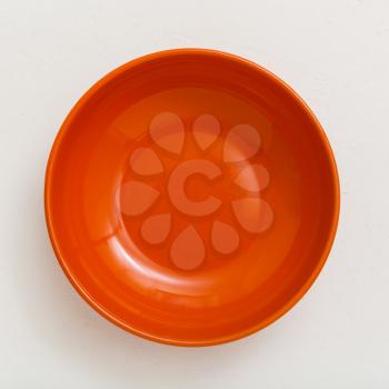 above view of orange bowl on white plastering plate