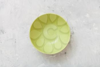 top view of green bowl on gray concrete plate